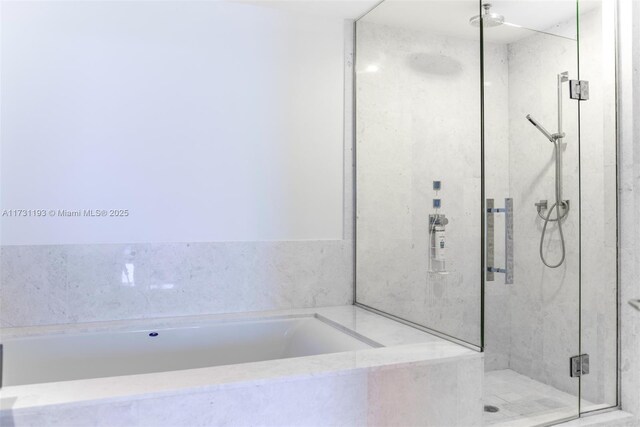 bathroom with vanity, tiled tub, and tile patterned flooring