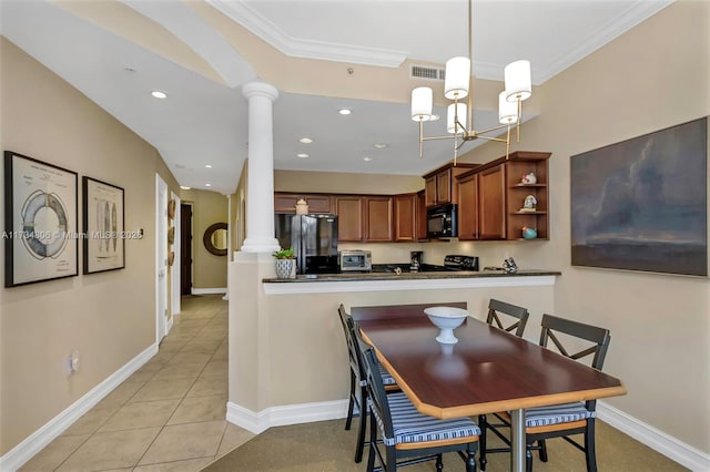 tiled dining room featuring a notable chandelier, ornamental molding, and ornate columns