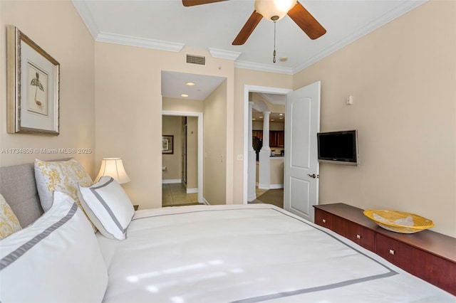 bedroom featuring ceiling fan, ensuite bath, and ornamental molding