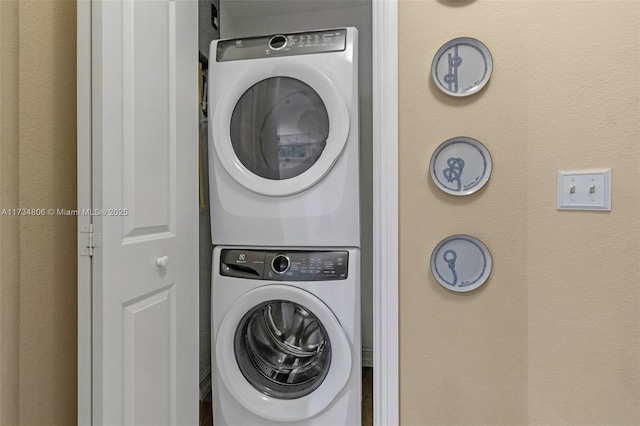 laundry area featuring stacked washer / drying machine