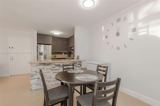 tiled dining area featuring crown molding