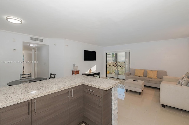 unfurnished living room with ornamental molding and light tile patterned floors