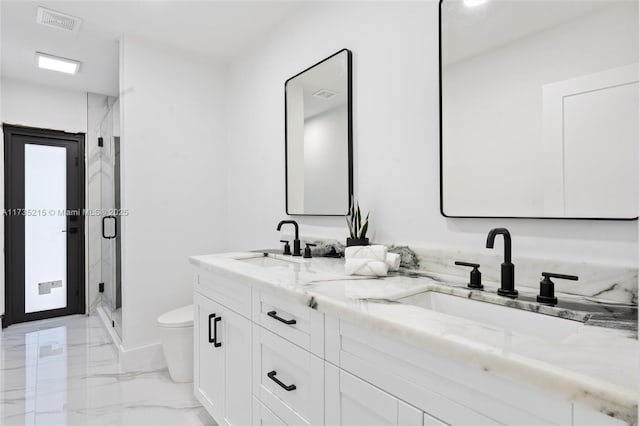 bathroom featuring vanity, toilet, and a shower with shower door