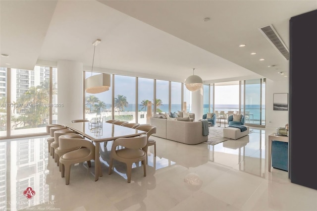 tiled dining room featuring a wall of windows and a water view