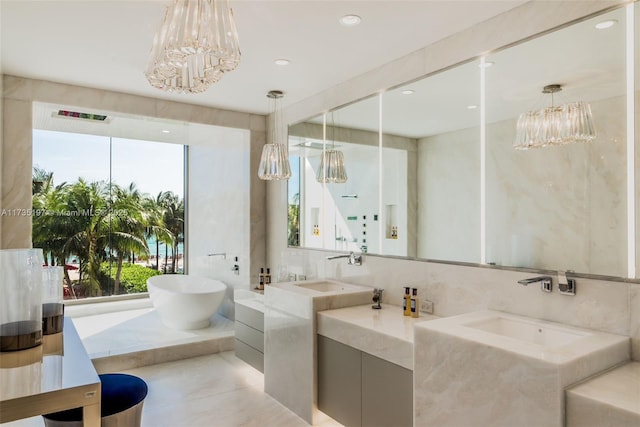 bathroom with vanity, a tub to relax in, tile walls, and an inviting chandelier