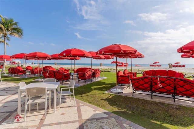 view of community featuring a patio, a water view, and a yard