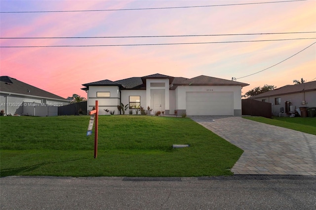 view of front of house featuring a garage and a lawn