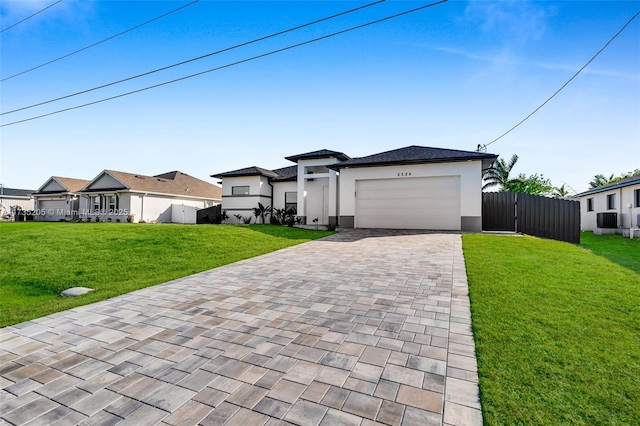 view of front of property with cooling unit, a garage, and a front lawn