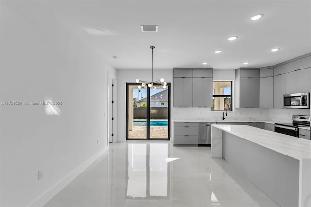 kitchen featuring sink, a center island, gray cabinets, pendant lighting, and stainless steel appliances