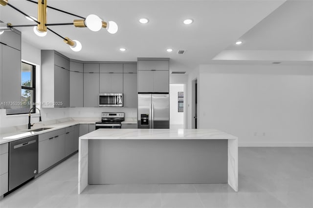 kitchen with gray cabinets, appliances with stainless steel finishes, and a large island