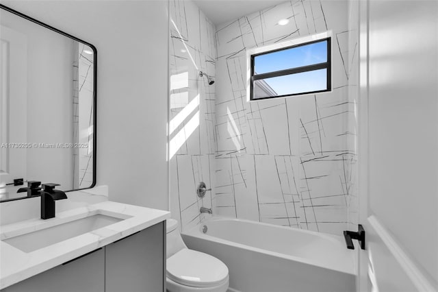 full bathroom featuring vanity, tiled shower / bath combo, and toilet