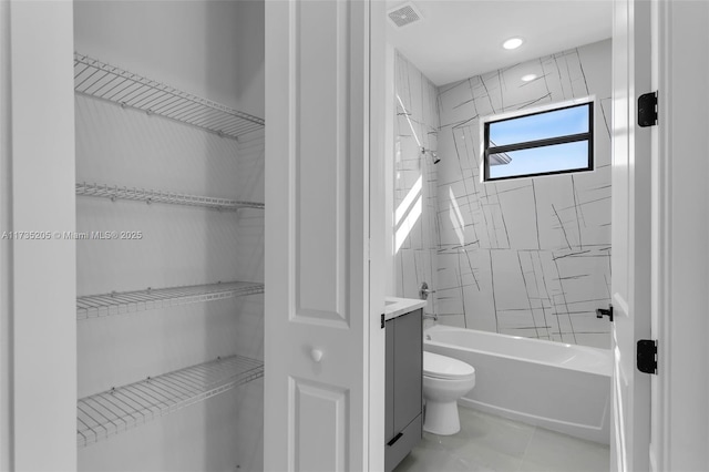 bathroom with tiled shower / bath, tile patterned floors, and toilet