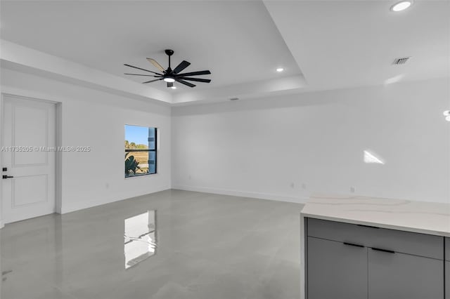 spare room with a tray ceiling and ceiling fan