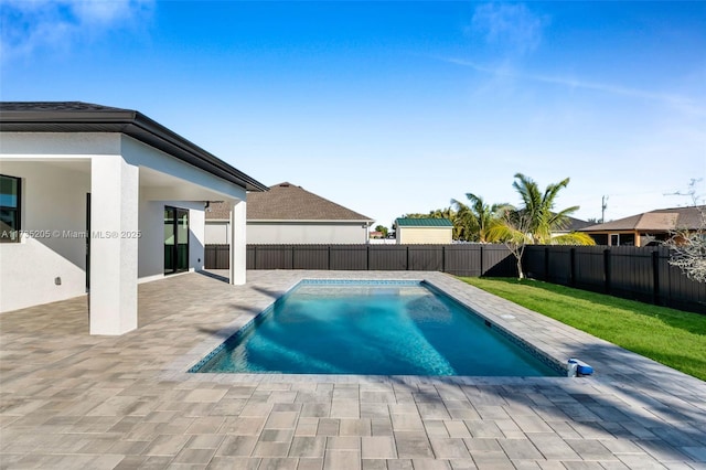 view of pool featuring a patio and a yard