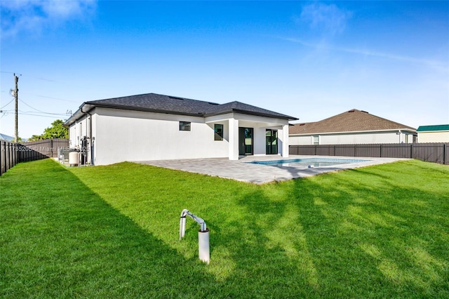 back of property featuring a fenced in pool, a patio area, and a lawn