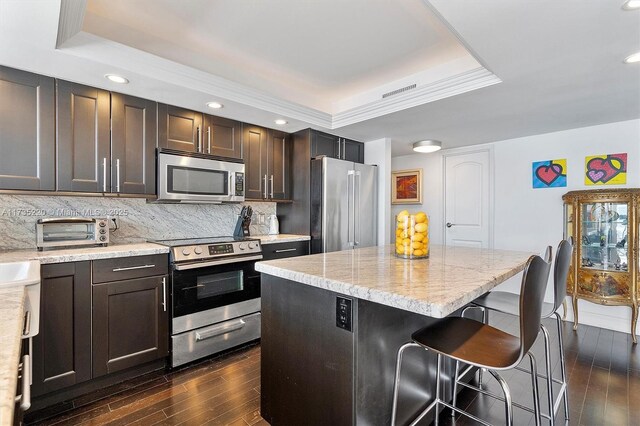 800 Parkview Dr Unit 1014, Hallandale Beach, FL 33009 - kitchen featuring appliances with stainless steel finishes, a toaster, backsplash, a tray ceiling, and dark wood-style floors
