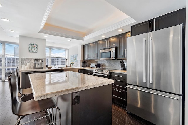800 Parkview Dr Unit 1014, Hallandale Beach, FL 33009 - kitchen with a sink, a raised ceiling, stainless steel appliances, decorative backsplash, and a kitchen island