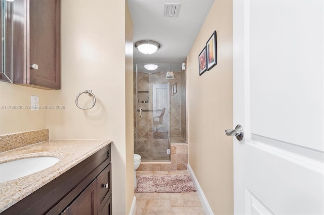 bathroom with vanity, a shower with shower door, and toilet