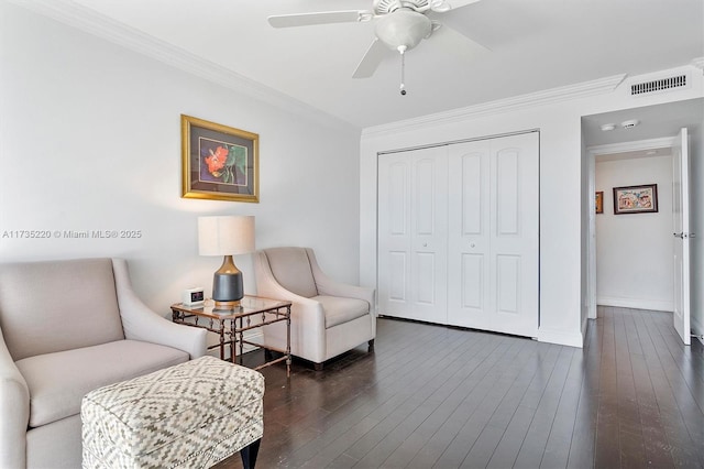 living area with crown molding, dark wood-type flooring, and ceiling fan