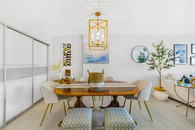 dining space with a notable chandelier and light hardwood / wood-style floors