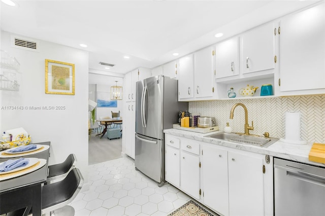 kitchen featuring white cabinetry, sink, tasteful backsplash, and stainless steel appliances