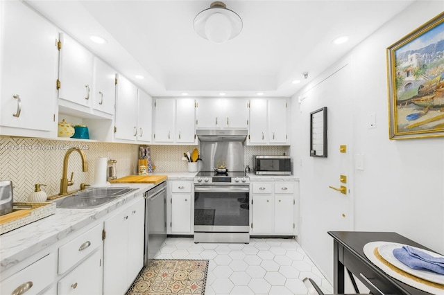 kitchen with stainless steel appliances, white cabinetry, sink, and tasteful backsplash