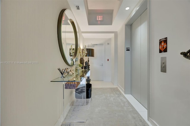 corridor featuring elevator and light tile patterned floors