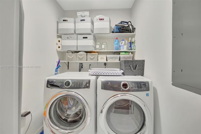 washroom with washing machine and clothes dryer and electric panel