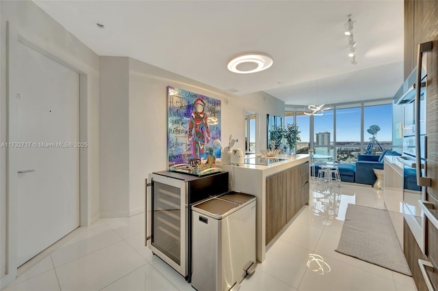 kitchen with fridge, light tile patterned floors, wine cooler, and a wall of windows