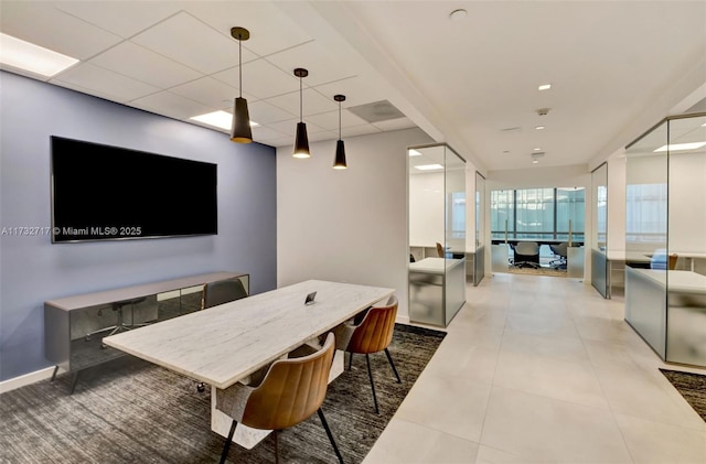 dining area featuring tile patterned floors and a drop ceiling