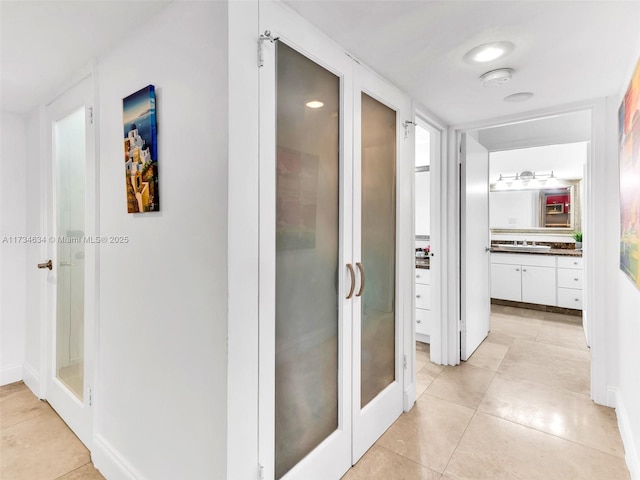 corridor with sink and light tile patterned floors