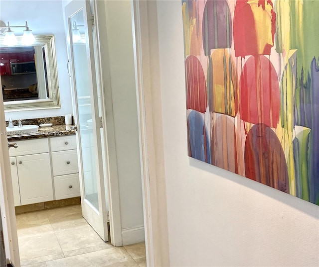 bathroom with walk in shower, tile patterned floors, and vanity