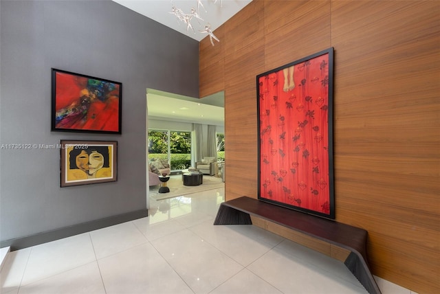 hall with a high ceiling and light tile patterned flooring