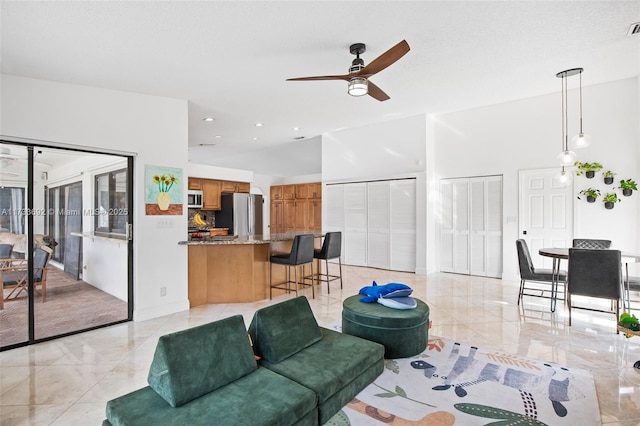 living room featuring ceiling fan and lofted ceiling