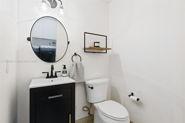 bathroom featuring washer / clothes dryer, vanity, and toilet