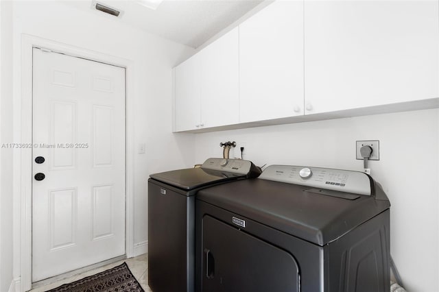 laundry area featuring cabinets and washer and clothes dryer