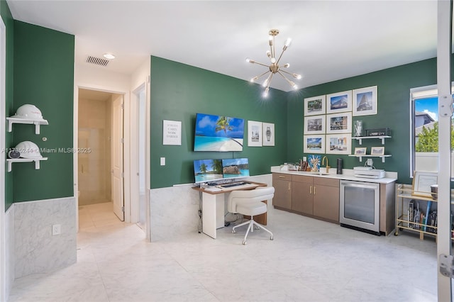 home office featuring wet bar, an inviting chandelier, and beverage cooler