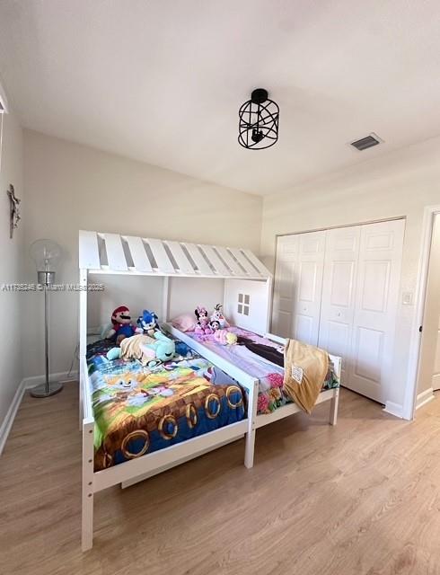 bedroom featuring wood-type flooring and a closet