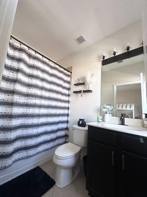 bathroom featuring vanity, toilet, and tile patterned flooring