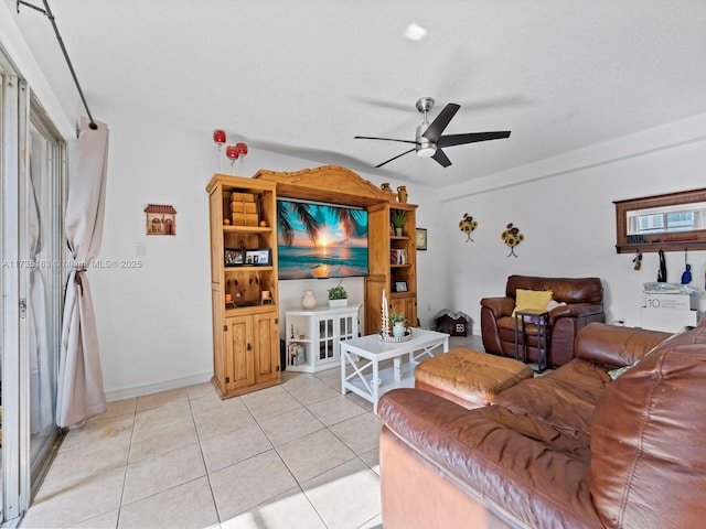 living room featuring light tile patterned flooring, ceiling fan, and a textured ceiling