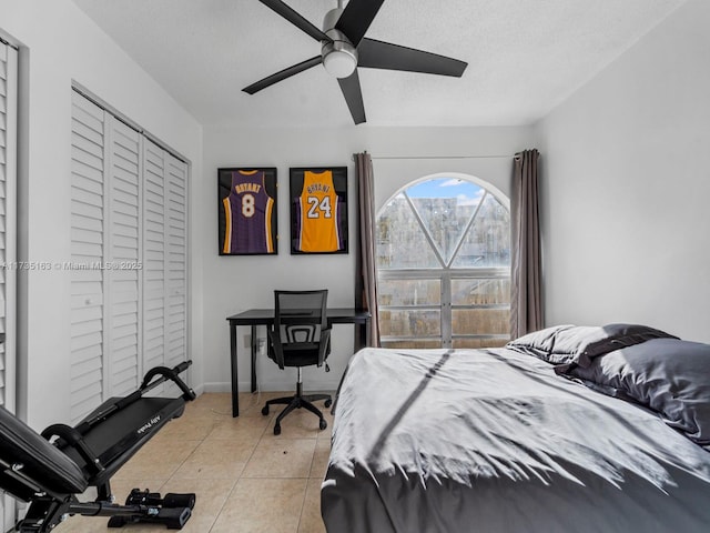 tiled bedroom featuring ceiling fan and a textured ceiling