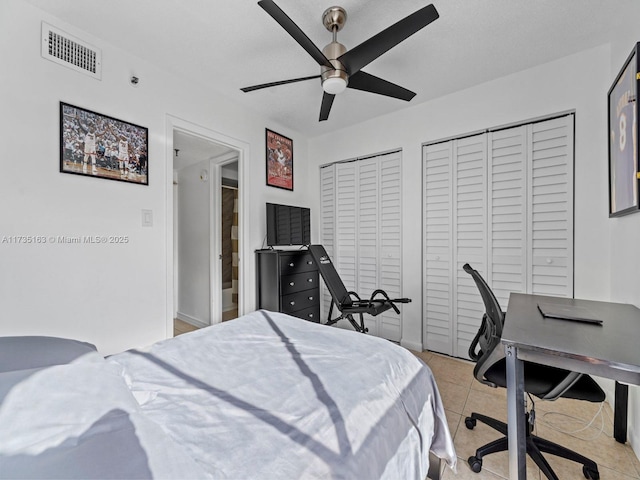 bedroom with ceiling fan, two closets, and light tile patterned floors