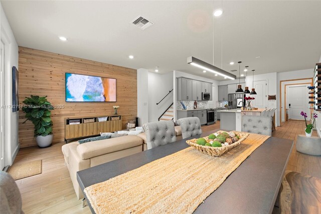 dining space featuring light hardwood / wood-style flooring and wooden walls