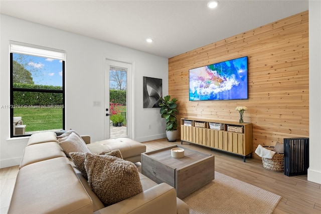 living room featuring wooden walls and light hardwood / wood-style floors