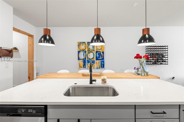 kitchen with sink, dishwasher, gray cabinetry, light stone countertops, and an island with sink