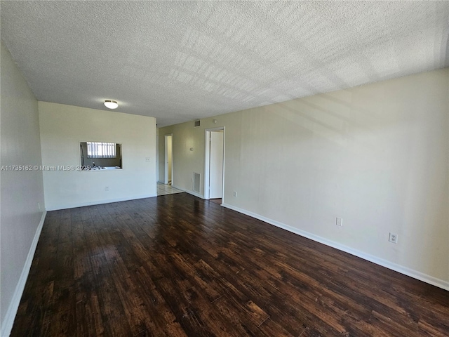 unfurnished room with wood-type flooring and a textured ceiling