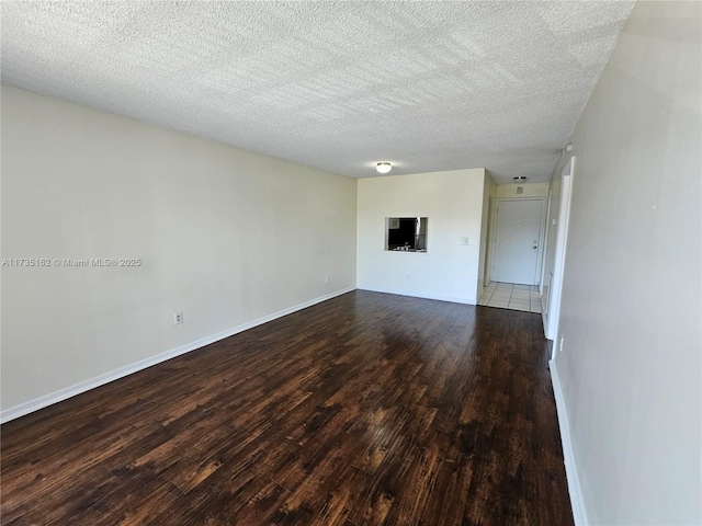 unfurnished room with hardwood / wood-style floors and a textured ceiling