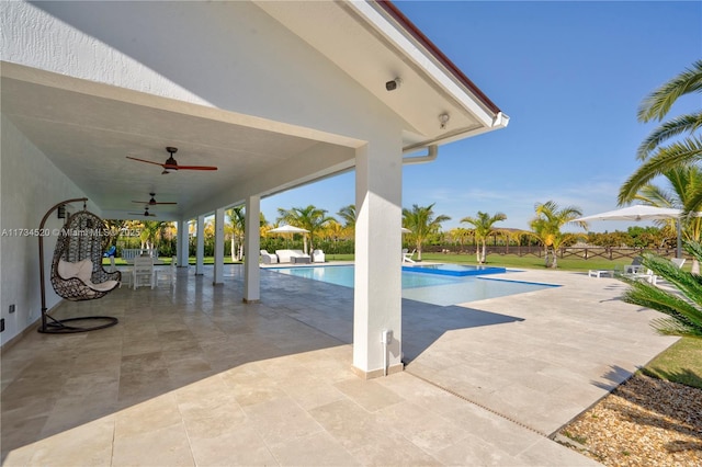 view of swimming pool with ceiling fan and a patio