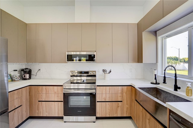 kitchen with backsplash, stainless steel appliances, and sink