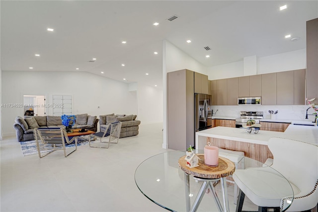 dining area featuring high vaulted ceiling and sink